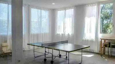 a ping pong table in a room with windows at Catalunya Casas Majestic Villa and Views , 30km to Barcelona in Corbera de Llobregat