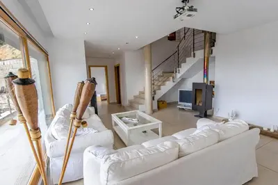 a living room with two white couches and a staircase at Catalunya Casas Modern Magnificence , only a few km to the beach! in Sant Cebrià de Vallalta