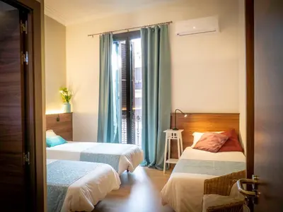 a hotel room with two beds and a window at Pension Ciudadela in Barcelona