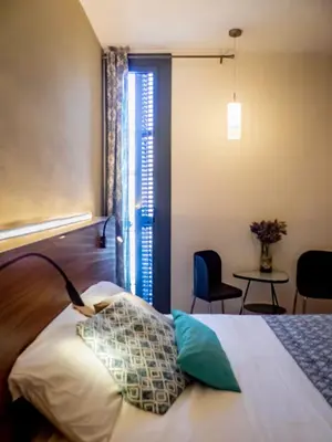 a bedroom with a bed and a table with chairs at Pension Ciudadela in Barcelona