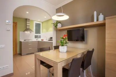 a kitchen with a dining room table with chairs and a tv at Bcngotic in Barcelona