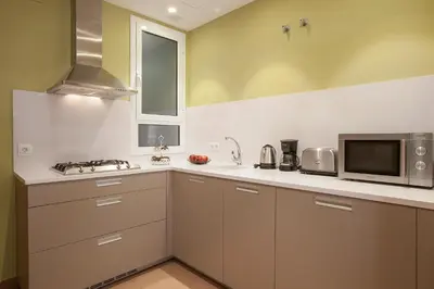 a kitchen with white cabinets and a microwave at Bcngotic in Barcelona