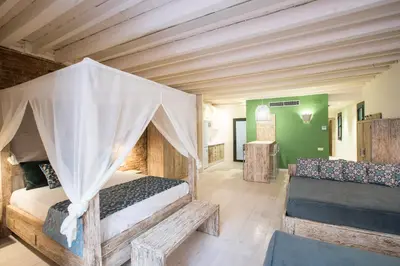 a bedroom with a canopy bed and a couch at La Bodega Suites in Hospitalet de Llobregat