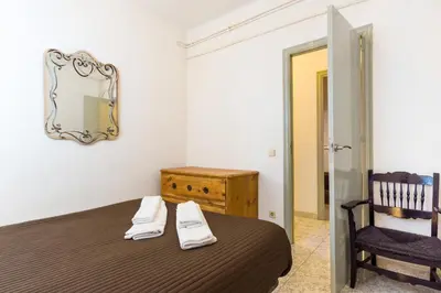 a bedroom with a bed with a mirror and a chair at Charm Apartment Sagrada Familia in Barcelona