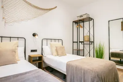two beds in a room with white walls at KeyFamily Lovely Villa in Barcelona