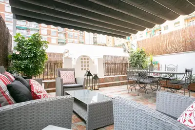 a patio with chairs and tables on a balcony at KeyFamily Lovely Villa in Barcelona