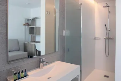 a bathroom with a sink and a shower with a mirror at Rocatel in Canet de Mar