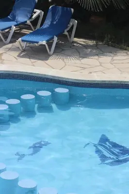 a swimming pool with two lawn chairs and a swimming at Rocatel in Canet de Mar