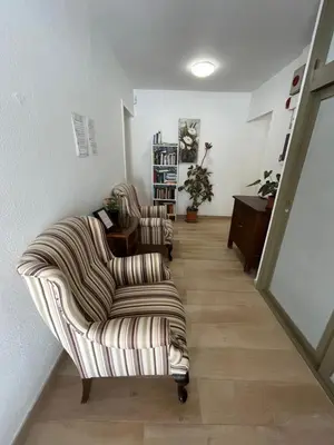 a living room with two chairs and a table at Hostal Casa Torrent in Canet de Mar