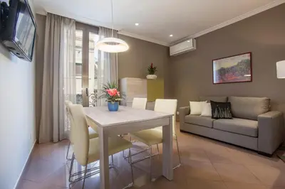 a dining room and living room with a table and a couch at BCNGOTIC43 in Barcelona