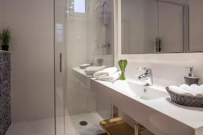 a white bathroom with two sinks and a shower at BCNGOTIC43 in Barcelona