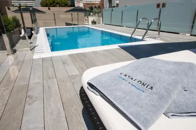 a towel is sitting on a bed next to a swimming pool at Catalonia Rigoletto in Barcelona