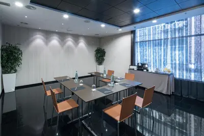 a conference room with a table and chairs and a counter at Catalonia Rigoletto in Barcelona
