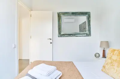 a white room with a mirror and towels on a bed at Jewel Home in Sant Pere de Ribes
