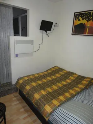 a bedroom with a bed with a blanket on the wall at Central Station Hostel Barcelona in Barcelona