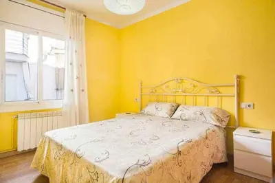 a bedroom with a bed with yellow walls and a window at Sitges Malvasia · Paz en el Corazón de Sitges in Sitges