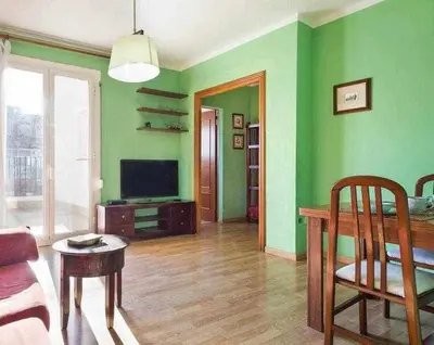 a living room with green walls and a television at Sitges Malvasia · Paz en el Corazón de Sitges in Sitges