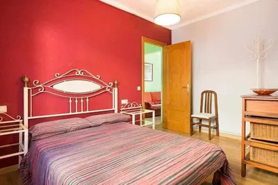 a bedroom with a red wall with a large bed at Sitges Malvasia · Paz en el Corazón de Sitges in Sitges