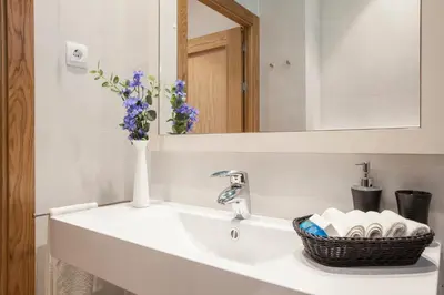 a bathroom with a sink with a vase of flowers at BCNGOTIC 42 in Barcelona