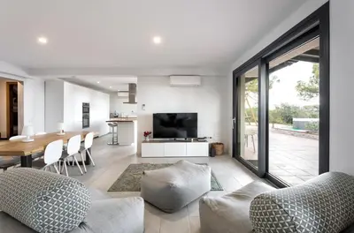a living room with a dining table and a television at Villa Costa Barcelona in Arenys de Munt