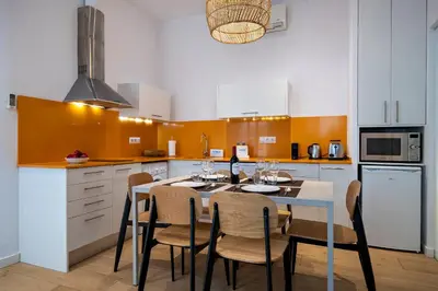a kitchen with a table and chairs in a kitchen at Verdi Habitat Apartments in Barcelona