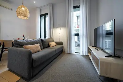 a living room with a couch and a flat screen tv at Verdi Habitat Apartments in Barcelona