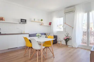 a kitchen and dining room with a table and yellow chairs at Flateli Providencia in Barcelona