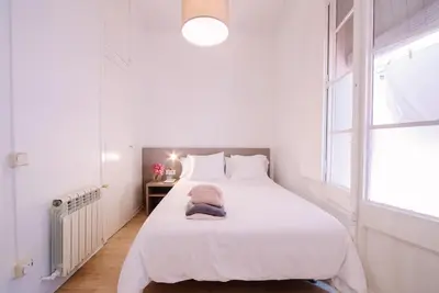 a white bedroom with a large white bed and a window at Hostalet de Barcelona in Barcelona