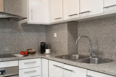 a kitchen with a sink and white cabinets at TSA Sepulveda in Barcelona