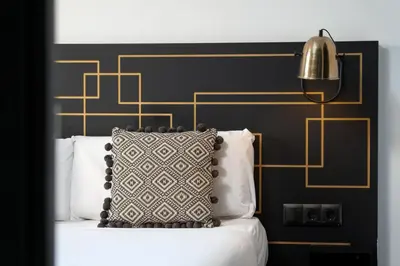 a black and gold bedroom with a bed with a pillow at TSA Sepulveda in Barcelona