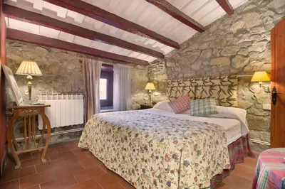 a bedroom with a bed and a stone wall at Sant Marçal del Montseny in Montseny