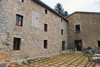 a large stone building with a patio in front of it at Sant Marçal del Montseny in Montseny