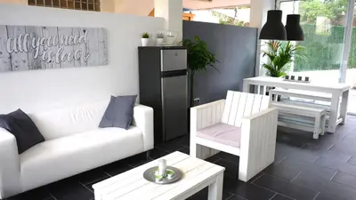 a living room with a couch and chairs and a table at Beach House in Castelldefels