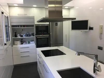 a white kitchen with a sink and a stove at Beach House in Castelldefels