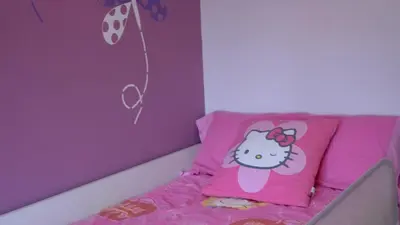 a room with a pink bed with a hello kitty pillow at Beach House in Castelldefels