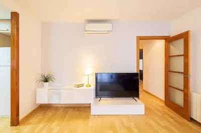 a living room with a flat screen tv on a white cabinet at Lucas House Apartments by Sitges Group in Sitges
