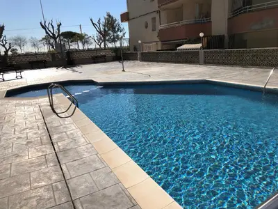 a large blue swimming pool next to a building at VicAm Atico Duplex in Pineda de Mar