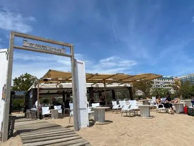 a beach with tables and chairs and umbrellas at VicAm Atico Duplex in Pineda de Mar