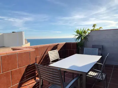 a table and chairs on a balcony with the ocean at VicAm Atico Duplex in Pineda de Mar