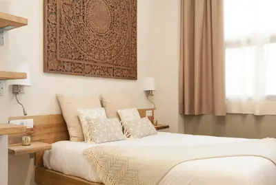 a bedroom with a bed with a picture on the wall at Hotel Radha in Hospitalet de Llobregat