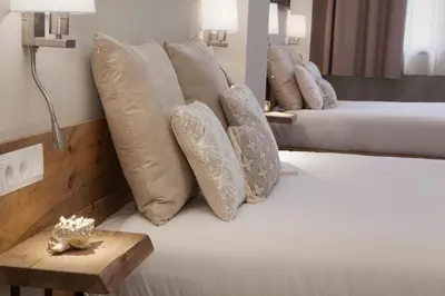 a room with two beds with pillows and a table at Hotel Radha in Hospitalet de Llobregat