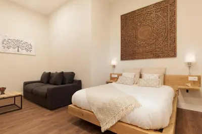 a bedroom with a large bed and a couch at Hotel Radha in Hospitalet de Llobregat