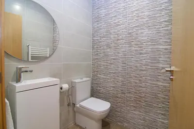 a bathroom with a toilet and a glass shower at Apartaments IXA in Manresa