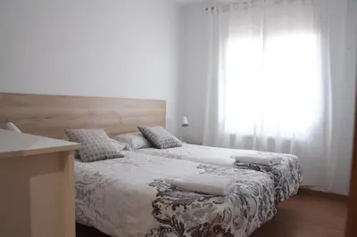 a bedroom with a bed and a large window at Apartaments IXA in Manresa