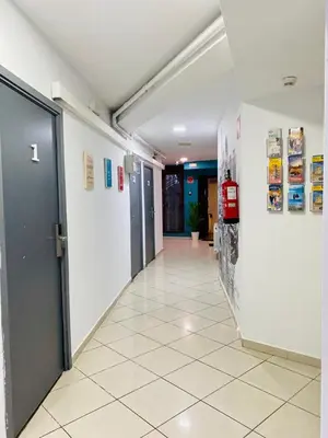 a hallway of a building with a door and a tile floor at Mellow Barcelona in Barcelona