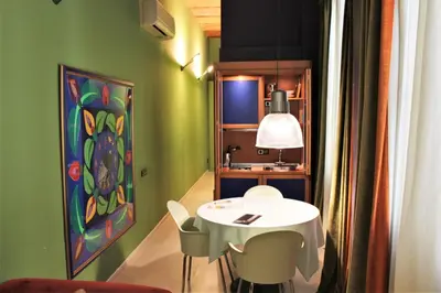 a table and chairs in a room with a painting at Apartaments Sant Jordi Girona 97 in Barcelona