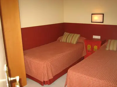 a small bedroom with two beds and a door open at Apartaments Sant Jordi Girona 97 in Barcelona