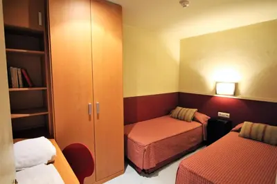 a small room with two beds and a closet at Apartaments Sant Jordi Girona 97 in Barcelona