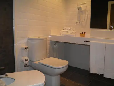 a white bathroom with a toilet and a sink at Apartaments Sant Jordi Girona 97 in Barcelona