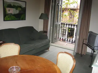 a living room with a couch and a table and a television at Apartaments Sant Jordi Girona 97 in Barcelona